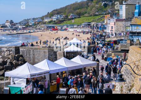 Lyme Regis, Dorset, Großbritannien. April 2021. Wetter in Großbritannien. Massen strömen in den Badeort Lyme Regis, um die warme Sonne und den strahlend blauen Himmel zu genießen. Viele sind in der Stadt, um das Eat Local Food and Drink Festival zu genießen, da die Stadt im Laufe der Jahre wieder normal wird. Eat zielt darauf ab, die besten Lebensmittel- und Getränkehersteller und Kunsthandwerker aus dem West Country in einer gut geführten, sicheren Umgebung im Freien zusammenzubringen. Kredit: Celia McMahon/Alamy Live Nachrichten Stockfoto