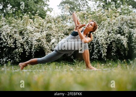 Das gebräunte junge Mädchen ist im Yoga engagiert. Stockfoto