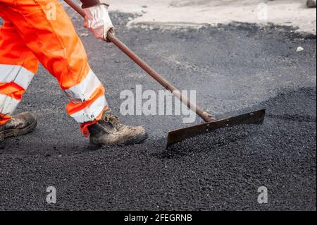 Mann bei der Arbeit während des Tarrings der Stadtstraßen Stockfoto