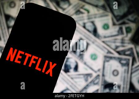 In dieser Abbildung ist ein Logo der Netflix-App für Online-Streaming-Unternehmen zu sehen, das auf einem Smartphone mit Dollarscheinen im Hintergrund angezeigt wird. (Foto von Filip Radwanski / SOPA Images/Sipa USA) Stockfoto