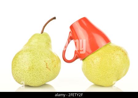 Zwei grüne reife Birnen mit einer roten Keramikschale, Nahaufnahme, auf weißem Hintergrund. Stockfoto