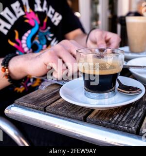 Epsom Surrey, London England, Großbritannien, April 23 2021, Anonymous junger Mann sitzt an EINEM Kaffeetisch mit EINER Tasse Espresso Stockfoto