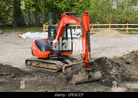 Pontypridd, Wales - April 2021: Kleiner mechanischer Bagger, der zum Abräumen von Abfällen in Pontypridd verwendet wird. Stockfoto