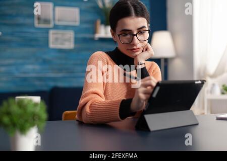 Student Designer Zeichnung Skizzen auf digitalem Tablet, während am Schreibtisch im Wohnzimmer sitzen., Schublade arbeiten an Grafik-Illustration mit professionellen Design Stift Retusche zeichnen Stockfoto