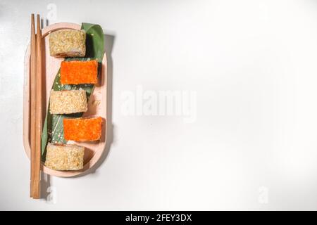 Sushi-Brötchen mit Reis und Fisch, Sojasauce auf weißem Hintergrund Stockfoto