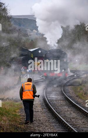 Historische Dampfeisenbahn oder Lok, die dramatische Rauchwolken aufblähen (Eisenbahnbegeisterte mit Kameras) - OXENHope Station Sidings, Yorkshire, England, Großbritannien. Stockfoto