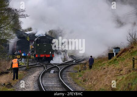 Historische Dampfeisenbahn oder Lok, die Rauchwolken aufblähen (Eisenbahner an den Punkten, Enthusiasten beobachten) - Oxenhope Station Sidings, Yorkshire England Großbritannien Stockfoto