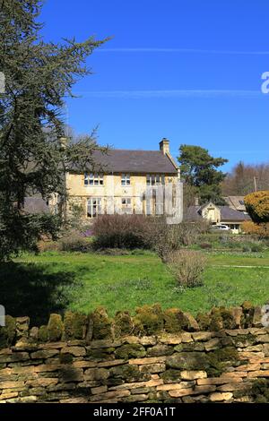 Hübsches Cotswold Steinhaus mit traditionellem Cotswold Trockensteingarten Mauer im kleinen Dorf Compton Abdale in Gloucestershire Stockfoto