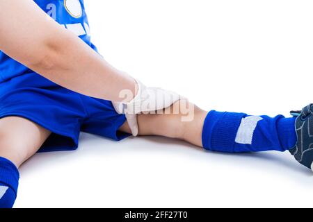 Sportverletzung. Arzt führen eine Kontrolle und erste Hilfe am Oberschenkel des jungen asiatischen Fußballspielers mit Schlagschatten, auf weißem Hintergrund. Studioaufnahme. Gratis fo Stockfoto