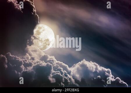 Attraktives Foto eines Nachthimmels mit Wolken, heller Vollmond würde einen tollen Hintergrund bilden. Schönheit der Natur und Kopierraum. Der Mond aufgenommen mit Stockfoto