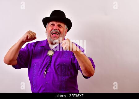 Blick auf einen älteren Mann sehr aufgeregt mit einem großen Lächeln und Hände mit den Fäusten auf einem weißen angehoben Stockfoto