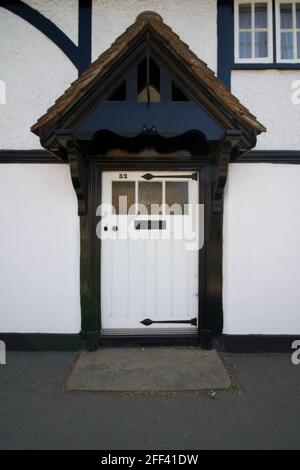 Alte englische weiße Eingangstür in einem denkmalgeschützten Gebäude im Tudor-Stil Stockfoto