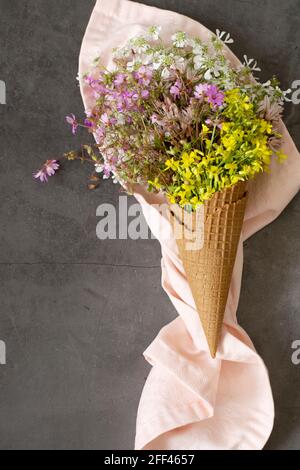 Waffeleis-Kegel gefüllt mit frischen Blüten aus Wildblumen Stockfoto