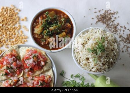 Indisches Gericht aus Basmati-Reis, gewürzt mit Kreuzkümmelsamen und Gewürzen. Vor Ort bekannt als Jeera-Reis serviert mit Flasche Gourd Curry mit Linsen und Cr Stockfoto