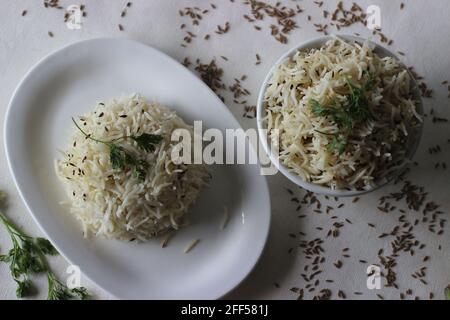 Indisches Reisgericht aus Basmati-Reis, gewürzt mit Kreuzkümmelsamen und Gewürzen. Lokal bekannt als Jeera Reis. Aufgenommen auf weißem Hintergrund. Stockfoto