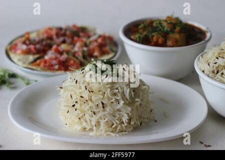 Indisches Gericht aus Basmati-Reis, gewürzt mit Kreuzkümmelsamen und Gewürzen. Vor Ort bekannt als Jeera-Reis serviert mit Flasche Gourd Curry mit Linsen und Cr Stockfoto