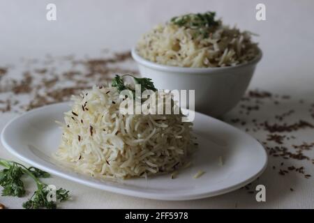 Indisches Reisgericht aus Basmati-Reis, gewürzt mit Kreuzkümmelsamen und Gewürzen. Lokal bekannt als Jeera Reis. Aufgenommen auf weißem Hintergrund. Stockfoto