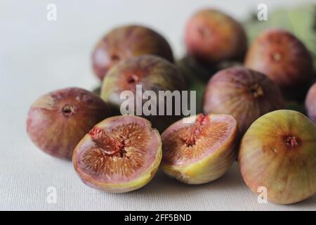 Reif und saftig frische Feigen ganz und halbiert. Aufgenommen auf weißem Hintergrund. Stockfoto