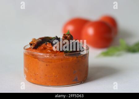 Hausgemachte, frische, würzige und heiße Würze mit Tomaten und roten Chilischoten. Lokal bekannt als Tomatenchutney. Aufnahme auf weißem Hintergrund. Stockfoto