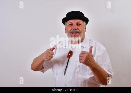 Ansicht eines älteren Mannes mit einem weißen Hemd und Ein Hut mit zwei Daumen nach oben auf weißem Hintergrund Stockfoto