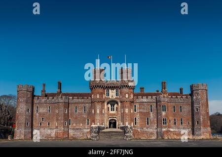 Herstmonceux Castle, East Sussex, Großbritannien. Eines der ältesten bedeutenden Backsteingebäude, das noch heute in England steht. Flagge der Flying Queen's University (Kanada) Stockfoto