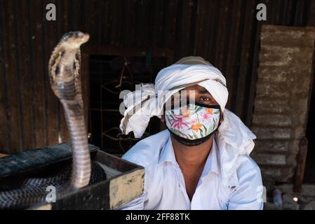 Dhaka, Dhaka, Bangladesch. April 2021. Ein Zigeuner, der während des Ausbruchs der Coronavirus-Krankheit (COVID-19) in Savar, am Stadtrand von Capital Dhaka, seine traditionelle Performance mit einer Cobra-Schlange macht. Die Flusszigeuner in Bangladesch sind lokal als Bede-Gemeinde bekannt. Quelle: Fatima-Tuj Johora/ZUMA Wire/Alamy Live News Stockfoto