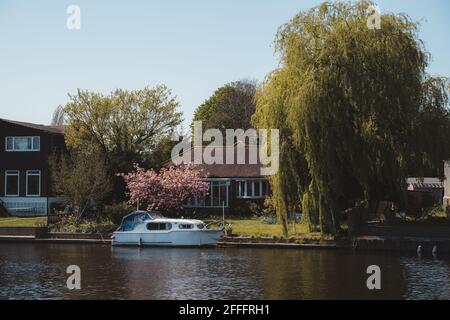 Staines-upon-Thames, Spelthorne - 2021.04.24: Die Boote liegen neben den schönen Häusern an der Themse in Staines Stockfoto