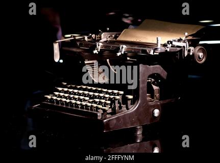 Vintage mechanische Schreibmaschine mit installiertem Papierblatt auf schwarzem Hintergrund Konzeptfotografie Nahaufnahme Stockfoto