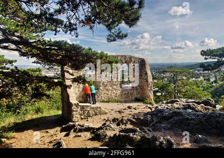 Das Paar ruht auf einer Führung durch die Burgruinen und blickt auf die Stadt Modling. Tourismus-, Wander- und Reisekonzept. Mödling-Österreich Stockfoto