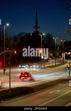 Hamburg, Deutschland. April 2021. Nach dem Start der Nachtflucht fahren Autos über die Kreuzung Glockengießerwall/Ballindamm an der Binnenalster (Wischeffekt durch lange Belichtung). Der Fernsehturm ist im Hintergrund zu sehen. Seit dem 24. April 2021 ist die Verordnung einer landesweiten Notausflußsperre für Länder mit einer siebentägigen Inzidenz von mehr als 100 neuen Coronainfektionen in Kraft. Dazu gehören unter anderem Sperrungen zwischen 10 und 5 Uhr. Quelle: Georg Wendt/dpa/Alamy Live News Stockfoto