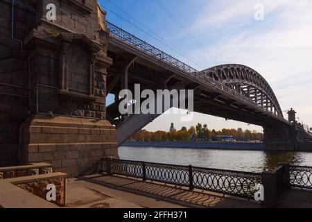 Metallbogenbrücke über den Fluss vor dem Hintergrund des bewölkten Himmels. Stockfoto