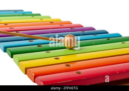 Xylophon-Musikinstrument mit Holzbalken in Regenbogen- und Maleta-Farben auf weißem, isoliertem Hintergrund. Stockfoto