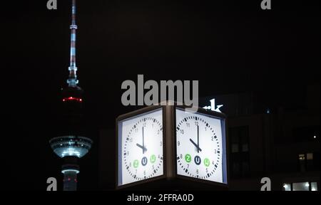 Berlin, Deutschland. April 2021. Unser Foto zeigt eine Uhr in Berlin mit dem Fernsehturm am Alexanderplatz im Hintergrund. Ein „hartes“ Coronavirus-Gesetz, das am Samstag in ganz Deutschland in Kraft trat. Es beinhaltet eine Sperrstunde von 10 bis 5 Uhr. Quelle: Paul Zinken/dpa-Zentralbild/dpa/Alamy Live News Stockfoto