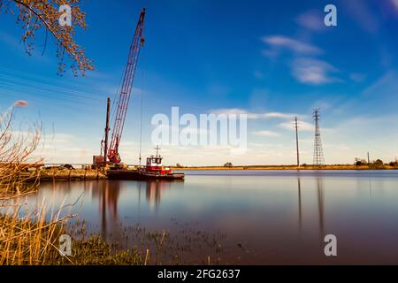 Ein Landschaftsbild der bildenden Kunst von einer Langzeitaufnahme des Nanticoke Flusses an der Küste von Wien, Maryland in der Nähe der Chestapeake Bucht. Ein Kran, ein angedockter Jahrgang Stockfoto