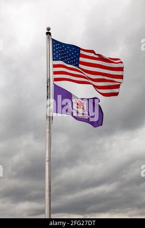 Flaggen der Vereinigten Staaten von Amerika und Talbot County, Maryland, fliegen gemeinsam auf einem Fahnenposten gegen den bewölkten Himmel. Isoliertes Bild mit Kopierer-SPAC Stockfoto
