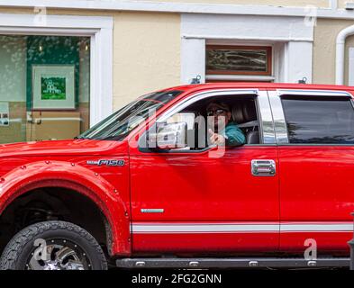 04-16-2021 Easton, MD, USA: Ein Mann mit Spitzbart fährt einen ford F-150 Pickup Truck. Er gibt ein Daumen nach oben Zeichen mit seiner Hand durch den Sieg Stockfoto