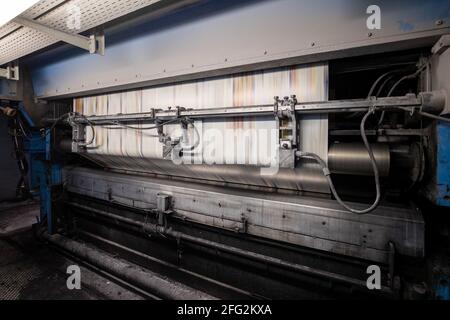Nürnberg, Deutschland. April 2021. Im Druckwerk Prinovis läuft eine Papierbahn durch eine Tiefdruckmaschine. Die Großdruckerei der zum Bertelsmann-Konzern gehörenden Prinovis-Gruppe mit Sitz in Nürnberg wird am 30. April 2021 schließen. Quelle: Daniel Karmann/dpa/Alamy Live News Stockfoto