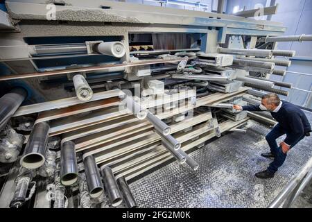 Nürnberg, Deutschland. April 2021. Im Druckwerk Prinovis läuft eine Papierbahn durch eine Tiefdruckmaschine. Die Großdruckerei der zum Bertelsmann-Konzern gehörenden Prinovis-Gruppe mit Sitz in Nürnberg wird am 30. April 2021 schließen. Quelle: Daniel Karmann/dpa/Alamy Live News Stockfoto