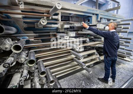 Nürnberg, Deutschland. April 2021. Im Druckwerk Prinovis läuft eine Papierbahn durch eine Tiefdruckmaschine. Die Großdruckerei der zum Bertelsmann-Konzern gehörenden Prinovis-Gruppe mit Sitz in Nürnberg wird am 30. April 2021 schließen. Quelle: Daniel Karmann/dpa/Alamy Live News Stockfoto