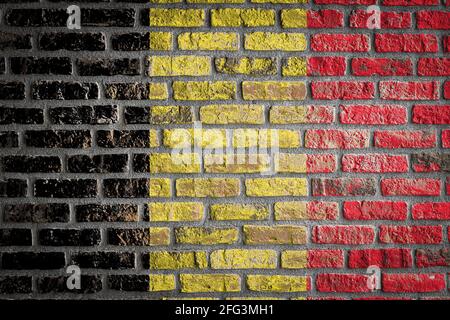 Nationalflagge Belgiens, die in Farbfarben auf einer alten Ziegelwand abgebildet ist. Flaggenbanner auf Backstein Wand Hintergrund. Stockfoto