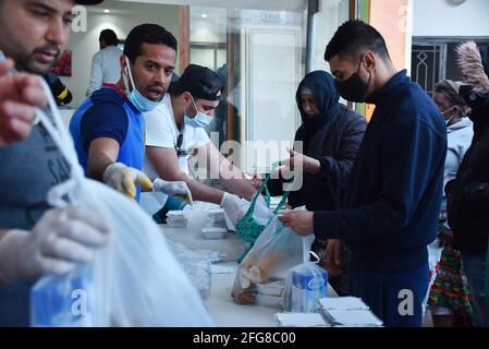 Tunis, Tunesien. April 2021. Tunesische Freiwillige verteilen während des muslimischen Fastenmonats Ramadan in der Ariana bei Tunis kostenlose Iftar-Mahlzeiten an die weniger privilegierten Menschen.EIN Restaurant im Distrikt Ariana erhält Hilfe von den Bewohnern (einem der Arbeiterviertel von Tunis), Verteilt ein kostenloses Iftar-Essen an mehr als 200 arme Tunesier und afrikanische Einwanderer während des Fastenmonats der Muslime im Ramadan. (Foto von Jdidi Wassim/SOPA Images/Sipa USA) Quelle: SIPA USA/Alamy Live News Stockfoto