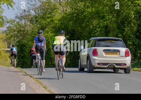 Überholen von Autos Radfahrern auf Landstraßen; Überholen von Radfahrern, Überholen von Fahrzeugen, Überholen von langsam fahrenden Fahrzeugen, Regel 188 des Straßenverkehrsgesetzes für vorbeifahrende Radfahrer auf Straßen. Stockfoto