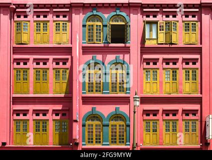 Farbenfrohes Vintage-Haus mit pinkfarbenem Äußeren und antiken Holzfensterläden im historischen Chinatown, Singapur Stockfoto