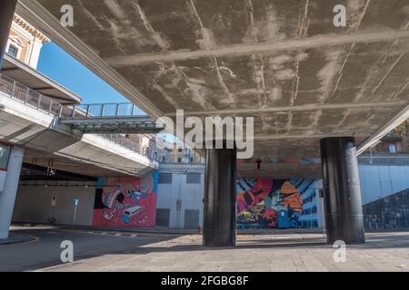 Blick unter einer Fußgängerbrücke mit großen schwarzen Säulen in der Nähe des öffentlichen Bahnhofs Parma, Italien: Keine Menschen. Stockfoto