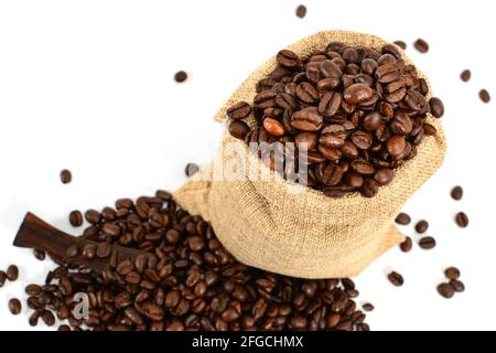 Kaffeebohnen. Jute-Burlack-Sack mit gerösteten Kaffeebohnen und Kaffeepatel mit abgeworfenen Bohnen. Isoliert auf weißem Hintergrund. Stockfoto