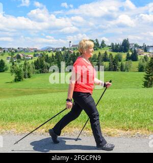 Frau, die in idyllischer Natur einen nordic Walking-Ausgehgang macht Sommerzeit Stockfoto