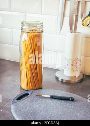 Küchentisch mit Spaghetti in einem Glas Stockfoto