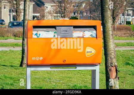 Orangefarbene öffentliche Mailbox Stockfoto