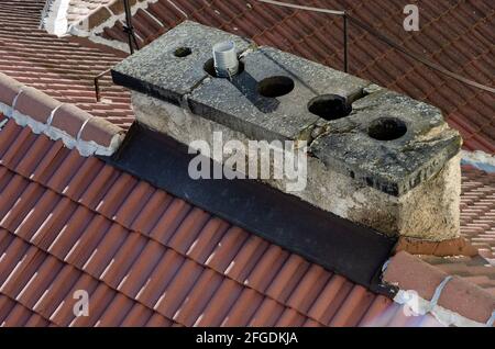 Alter rissiger Kamin auf dem Dach des Stadtgebäudes Stockfoto