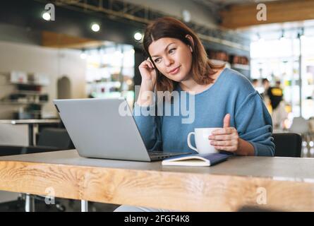 Schöne stilvolle junge Frau plus Größe Körper positiv mit Laptop im Schönheitssalon Büro, Inhaber eines kleinen Unternehmens Stockfoto
